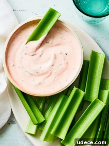 A plate of celery and Greek Yogurt Buffalo Dip in a bowl.
