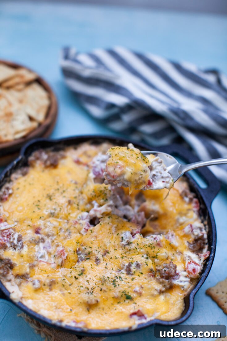 Creamy Skillet Sausage Dip Recipe for Game Day and Parties 6 a spoon scooping skillet sausage dip