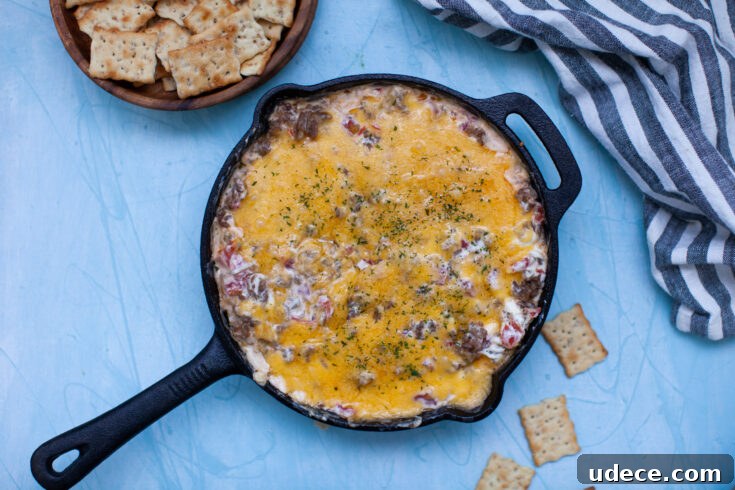 Creamy Skillet Sausage Dip Recipe for Game Day and Parties 8 a skillet with sausage dip and a kitchen towel