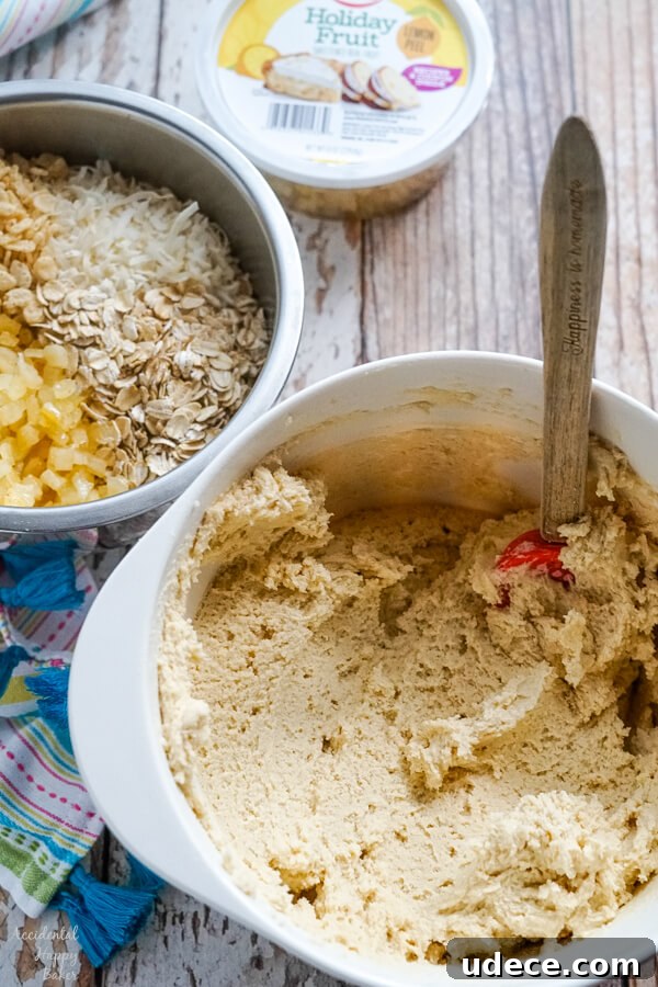 Zesty Lemon Cowboy Cookies Recipe for Soft, Chewy Treats 3 A bowl of cookie dough next to another bowl full of candied lemon peel, oats, coconut, and rice crispies.