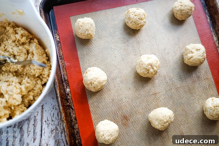 Zesty Lemon Cowboy Cookies Recipe for Soft, Chewy Treats 5 A sheet pan full of cookie dough that's been rolled into balls and is ready to bake.