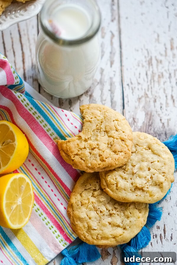 A stack of cookies on a striped towel next to a bottle of milk.