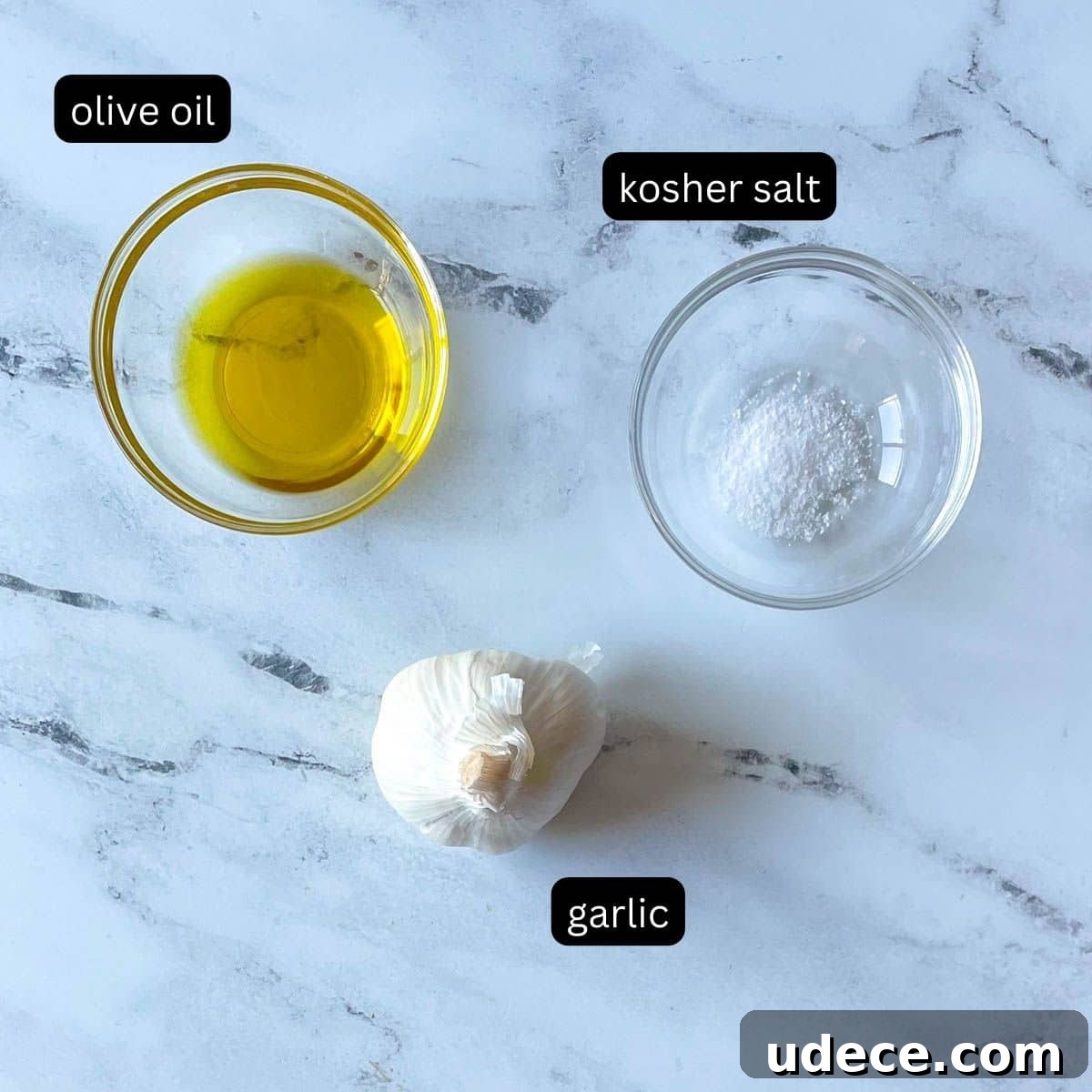 How to Roast Garlic Perfectly for Rich, Sweet Flavor 3 Olive oil, kosher salt, and a head of garlic are shown on a white marble counter.