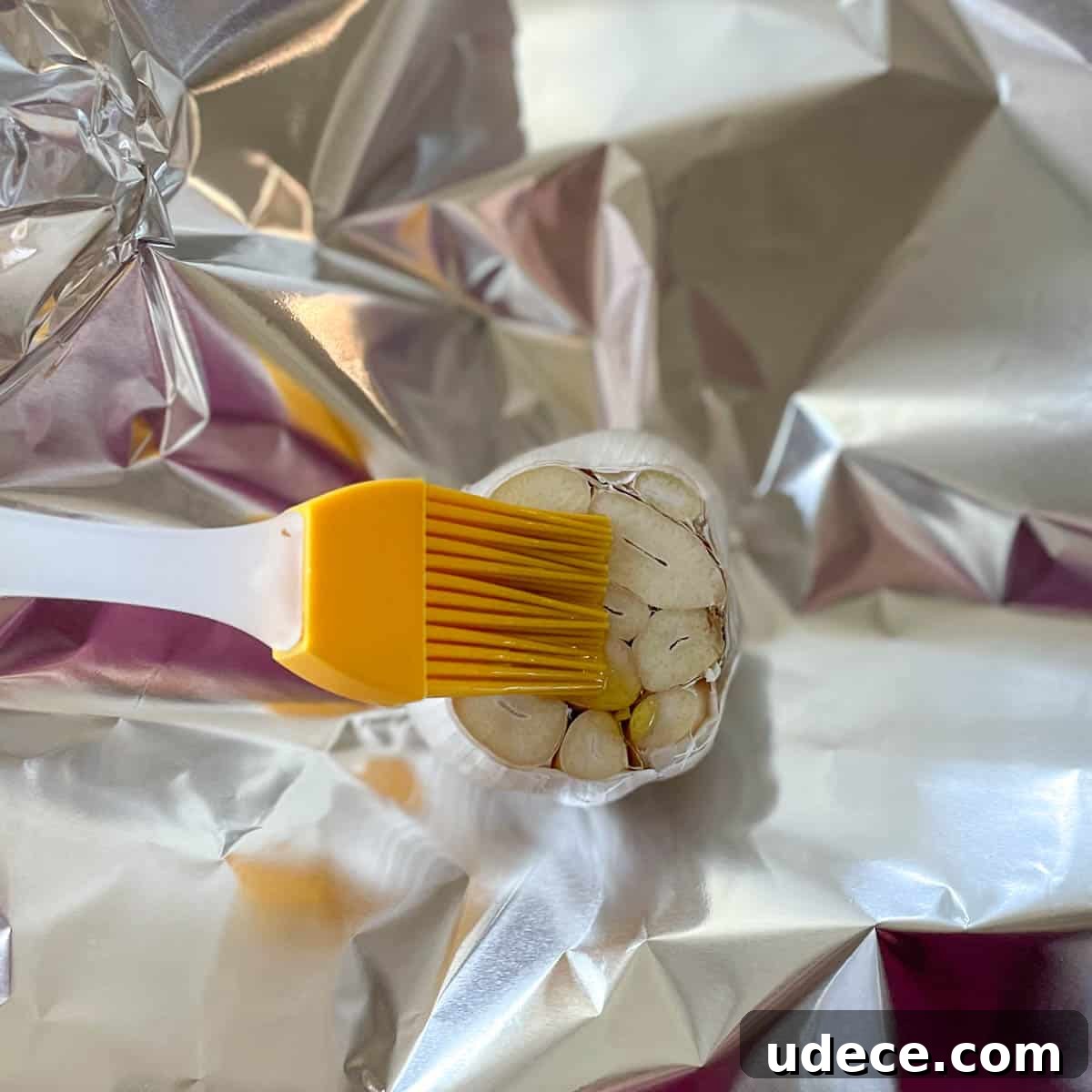 How to Roast Garlic Perfectly for Rich, Sweet Flavor 5 A head of garlic cut crosswise is brushed with olive oil.