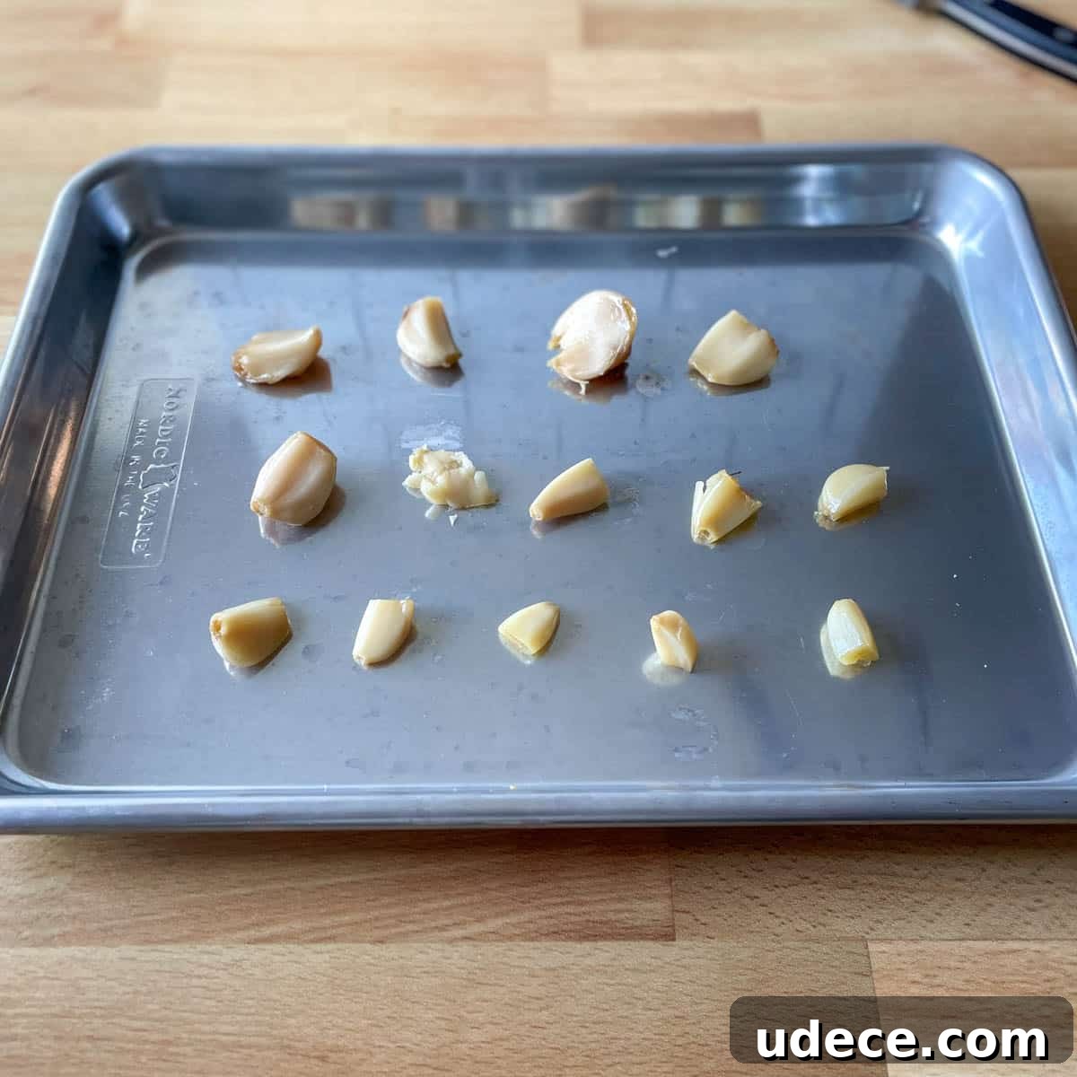 How to Roast Garlic Perfectly for Rich, Sweet Flavor 10 Peeled single cloves of garlic are shown in three lines on a small baking sheet.