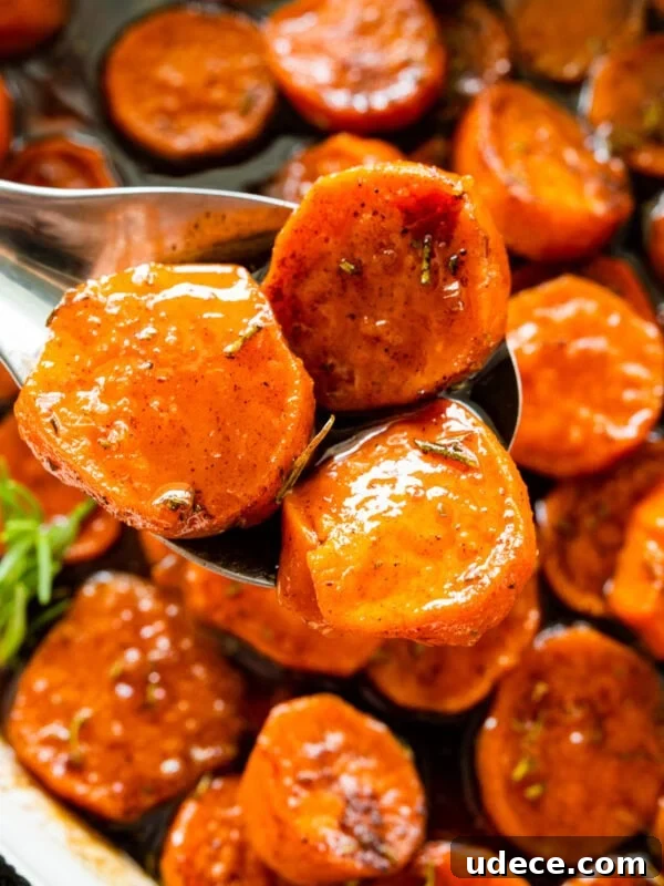 Classic Funeral Potatoes Recipe for Parties and Potlucks 15 candied sweet potatoes after the are baked. Fresh herbs on top for garnish. Spoon holding up a portion serving.