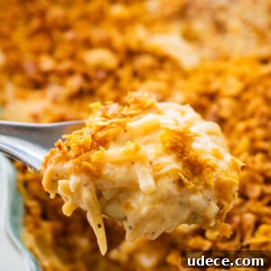 Classic Funeral Potatoes Recipe for Parties and Potlucks 18 A fork holding up one bite of party potatoes.