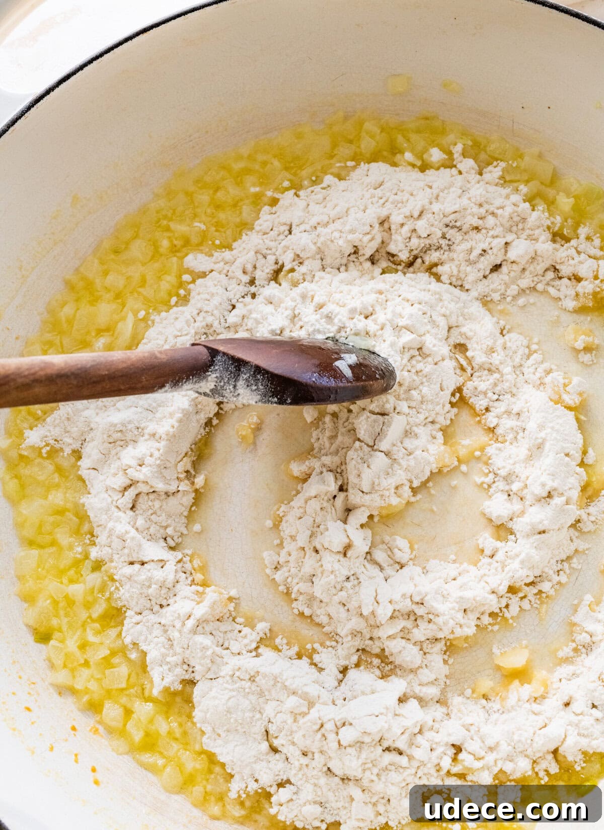Classic Funeral Potatoes Recipe for Parties and Potlucks 7 Stirring flour into a pan to make the roux.