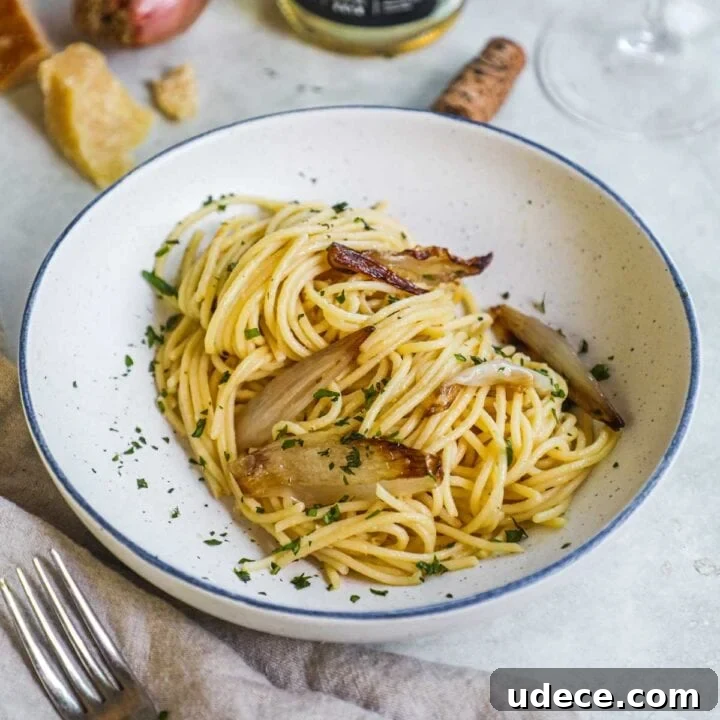 Miso spaghetti with caramelized shallots, Italian flat-leaf parlsey, and Parmigiano-Reggiano in a shallow pasta bowl.