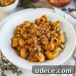 One-pot French onion pasta in a white porcelain bowl made with caramelized onions, gruyere, and herbed pangrattato.