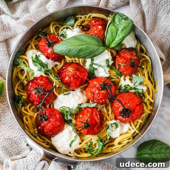 Roasted tomato pasta with globs of torn burrata cheese and fresh basil in a copper Mauviel pan.