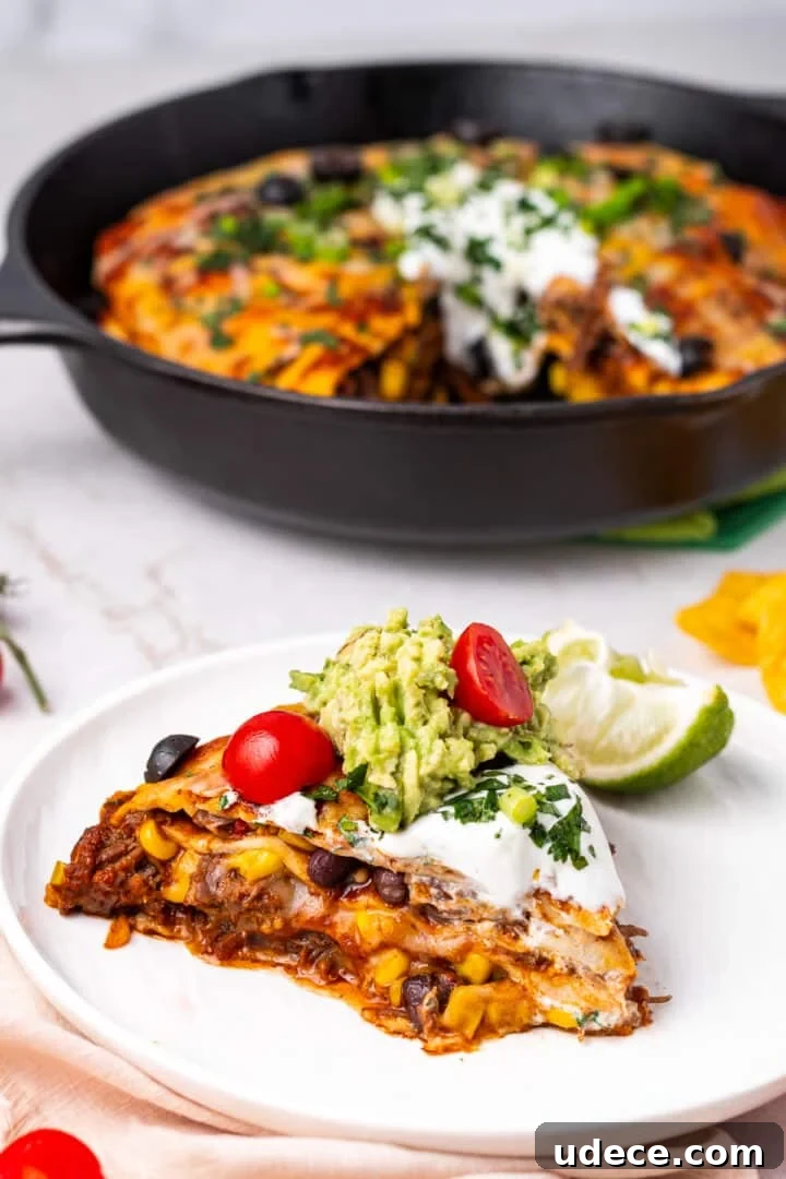 Cheesy Beef Enchilada Pie Recipe for Dinner Crowd-Pleasers 13 slice of shredded beef enchilada pie on a white plate