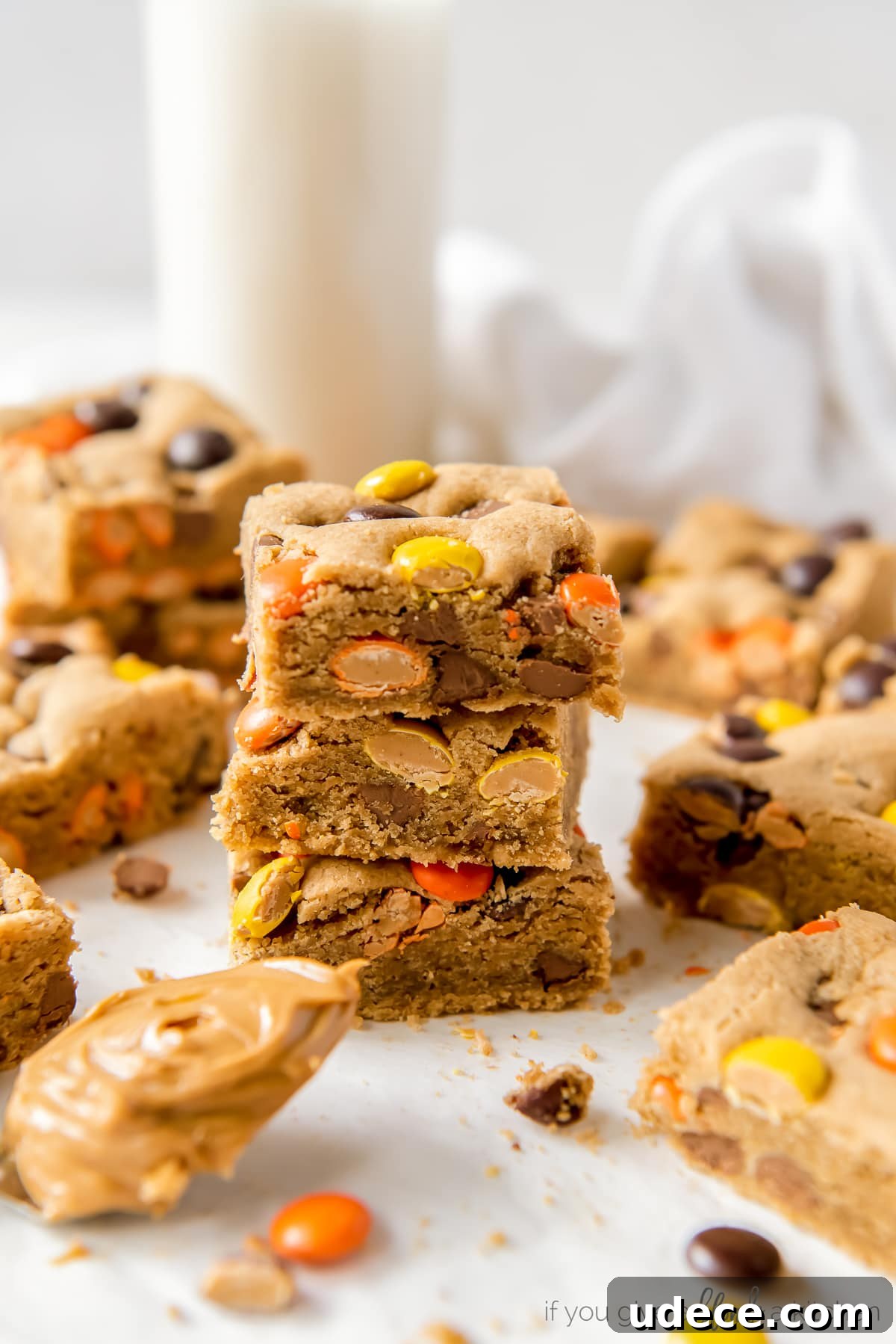three reeses pieces peanut butter blondies stacked on top of each other