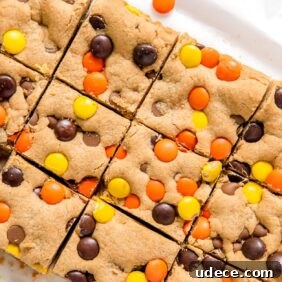 reeses pieces peanut butter blondies cut into squares on parchment paper