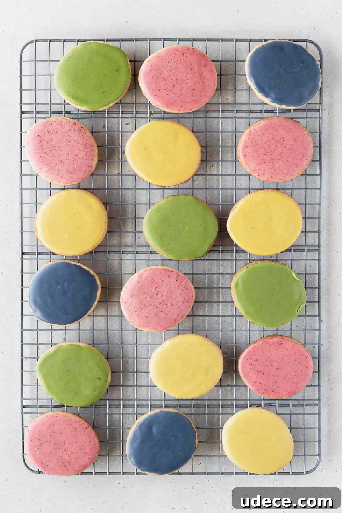 Blue, green, yellow, and pink vegan cookie icing in small bowls.