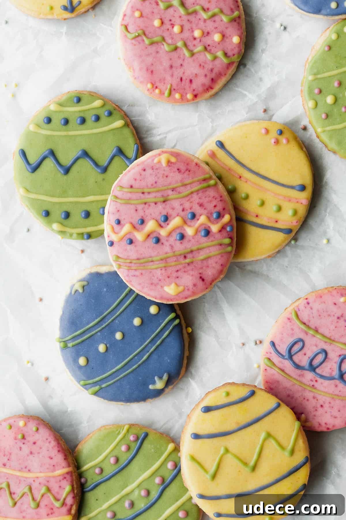 Overhead shot of decorated Easter cookies on a white surface.
