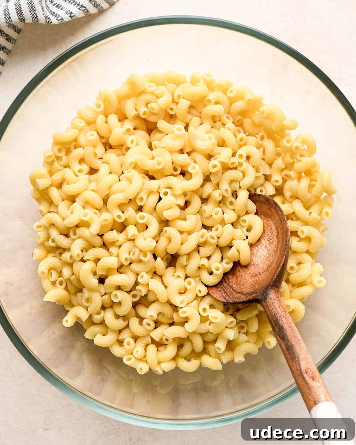 Classic Creamy Macaroni Salad Recipe 8 How to Make Macaroni Salad - cooked macaroni in a bowl with a wooden spoon