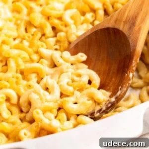 30+ Vegetarian Dinner Ideas That Make You Forget Meat Forever 10 A wooden spoon scooping mac and cheese from a baking dish.