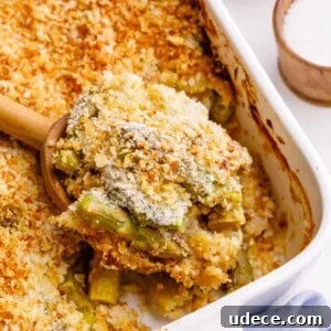 30+ Vegetarian Dinner Ideas That Make You Forget Meat Forever 8 A spoon lifting a bite of cheesy asparagus casserole.
