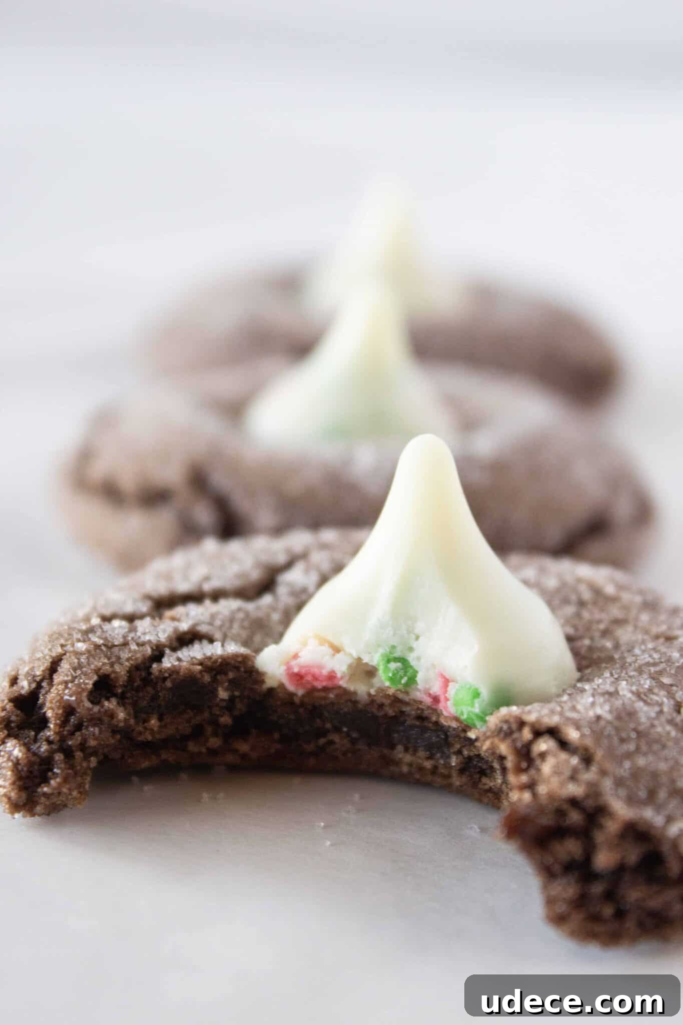 Chewy Chocolate Kiss Cookies Recipe: Classic Chocolate-Studded Cookies 6 Chocolate Kiss Cookies in a row with a bite taken from the first one.