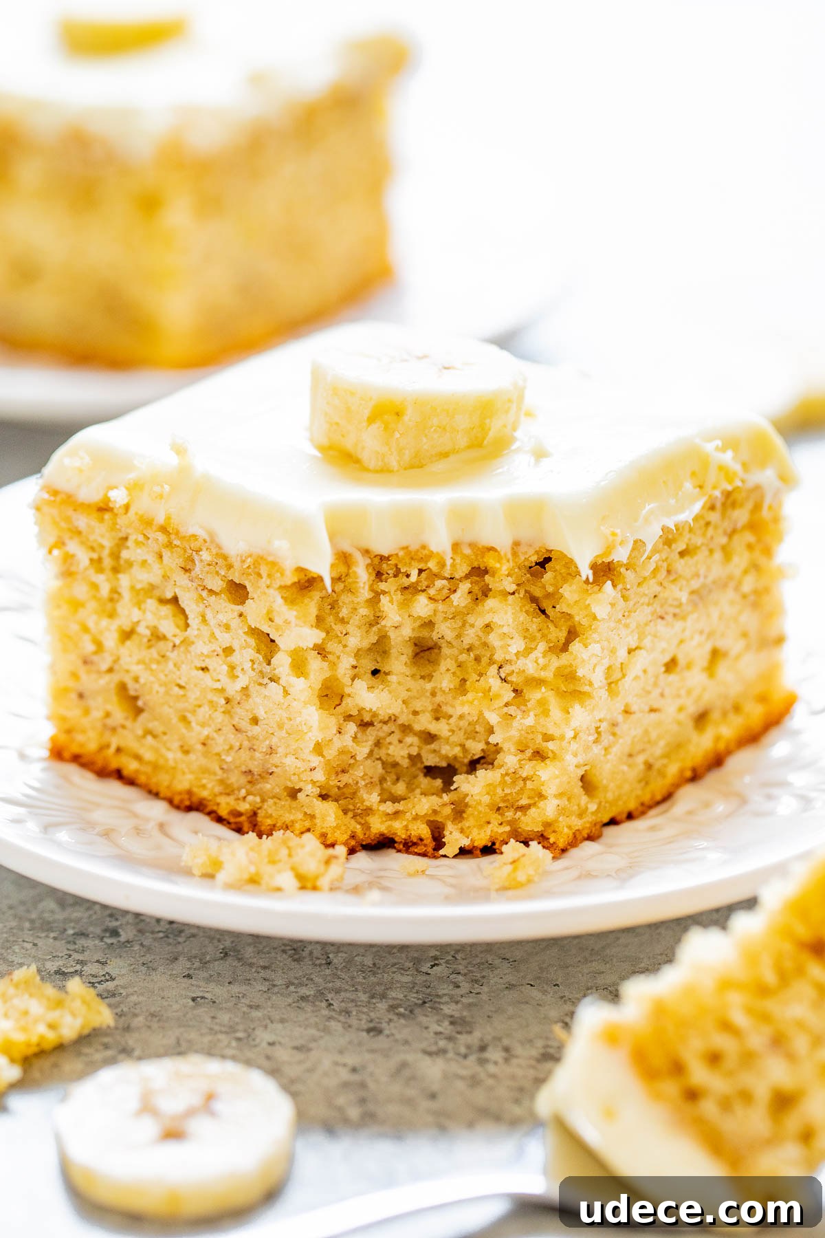 Best Banana Cake with Cream Cheese Frosting, a corner bite missing. 