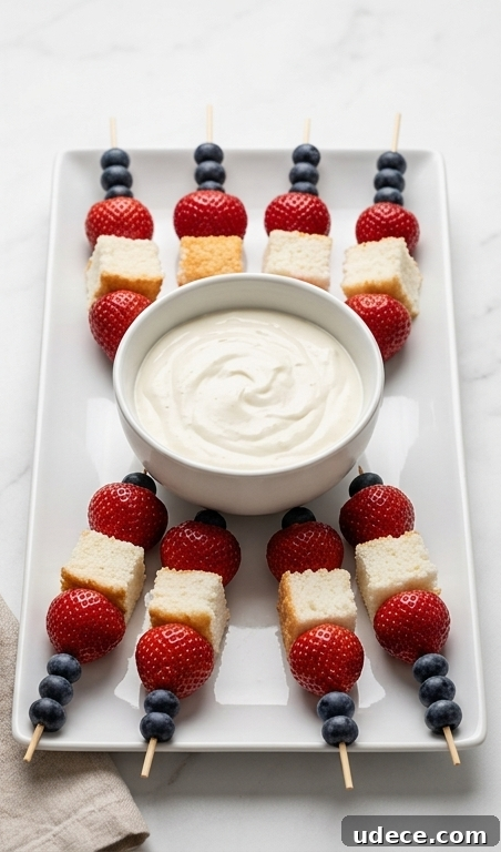 Red, White & Blue Fruit Skewers with Cheesecake Yogurt Dip Recipe 4 Skewers fanned around a bowl of dip