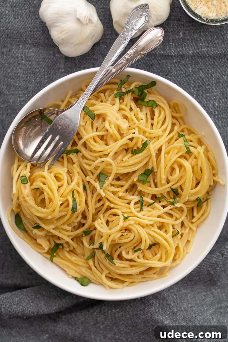 Garlic Butter Pasta with 4 Simple Ingredients 2 pasta with garlic butter sauce garnished with chopped basil in a white bowl