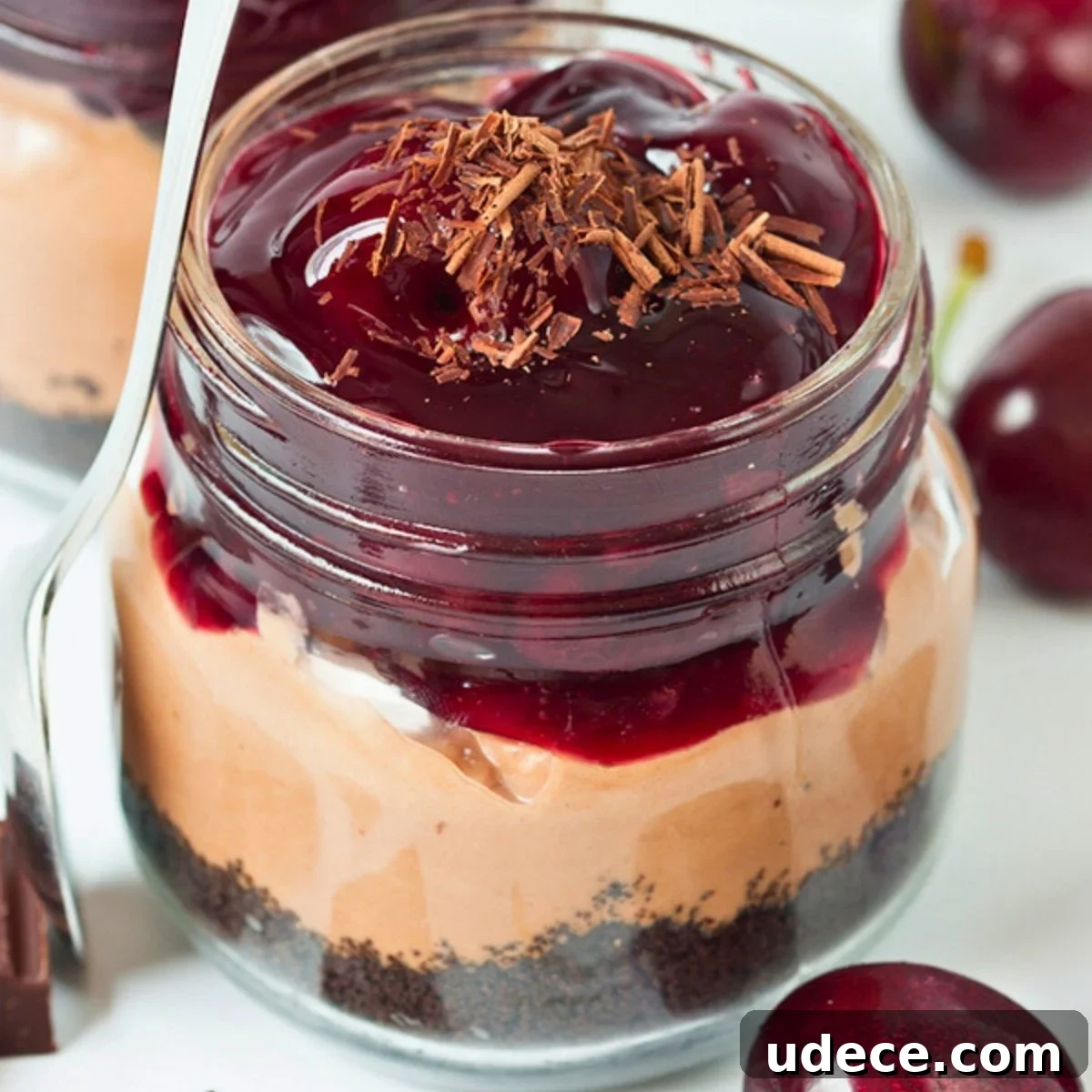 no-bake chocolate cherry cheesecakes made in mason jars for individual servings.