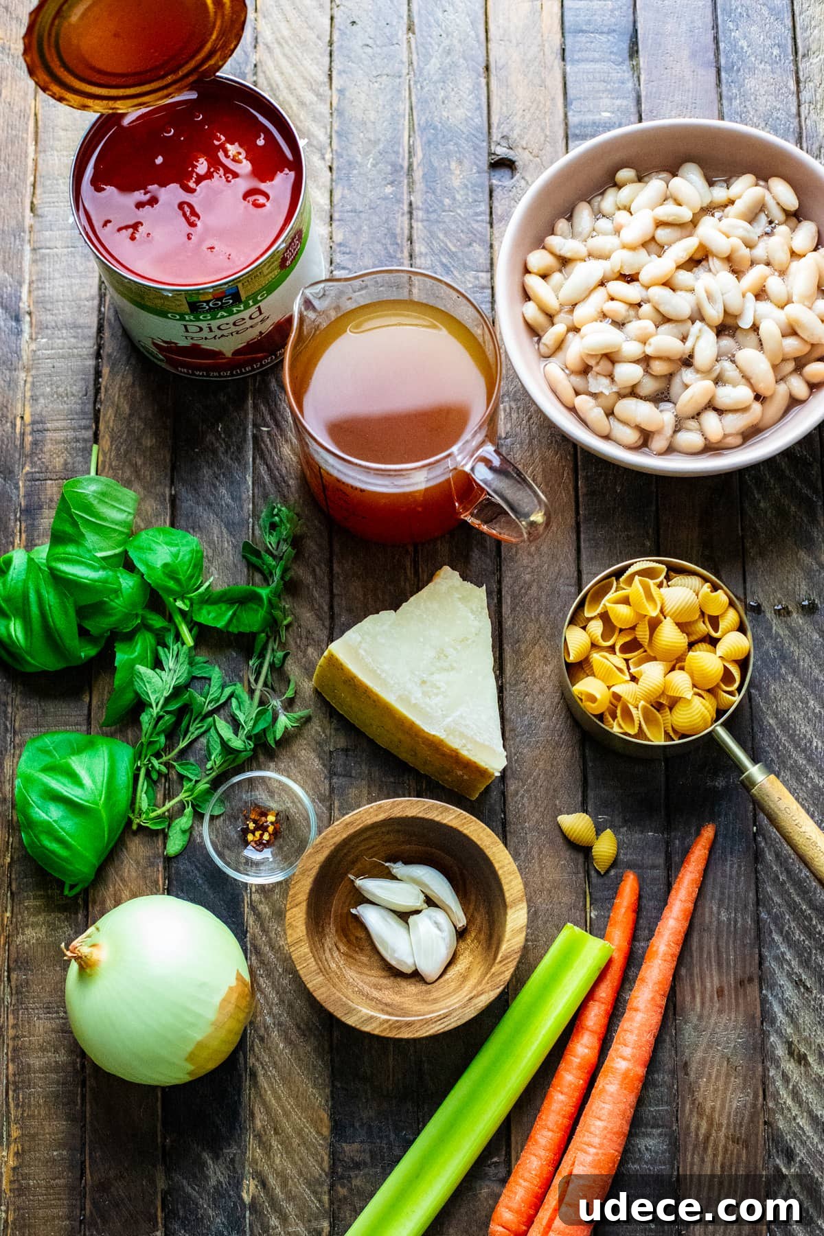 ingredients for pasta fagioli soup arranged on brown wooden board.