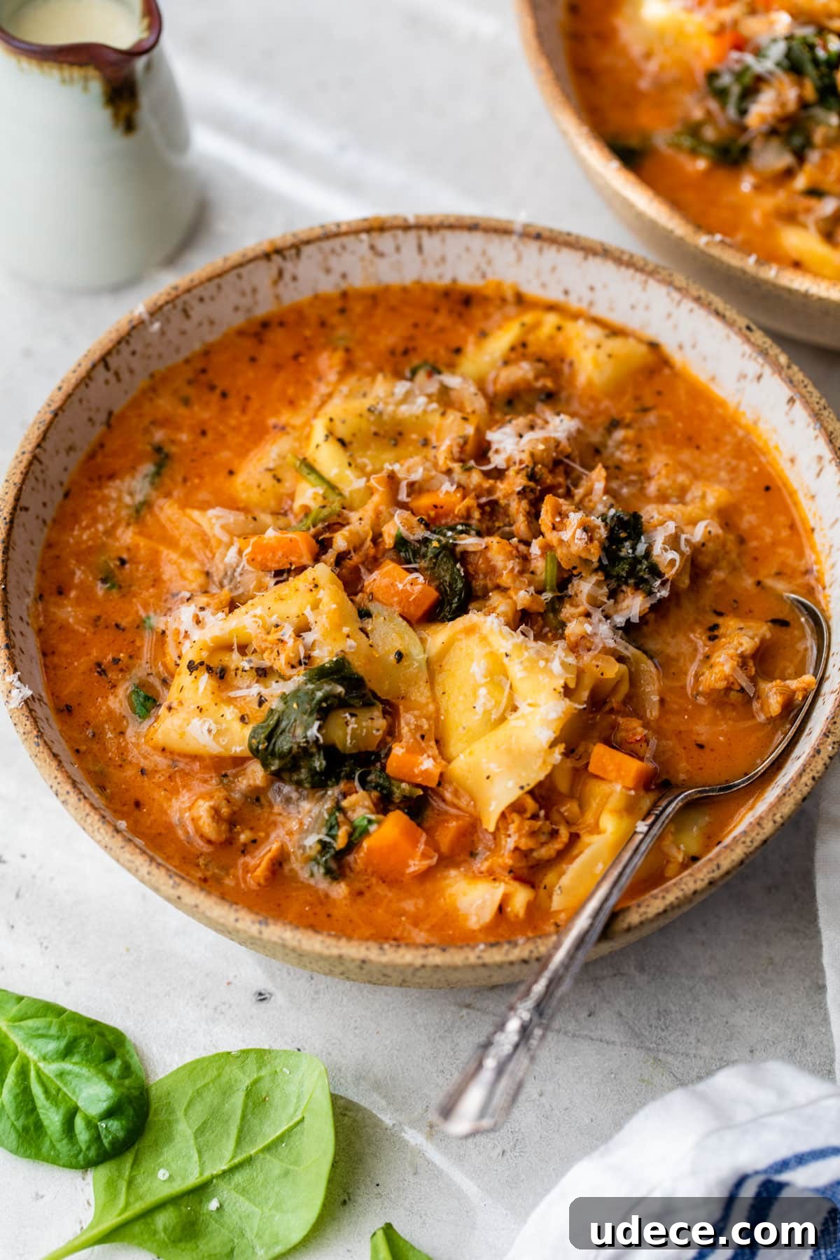 sausage tortellini soup in a bowl with a spoon