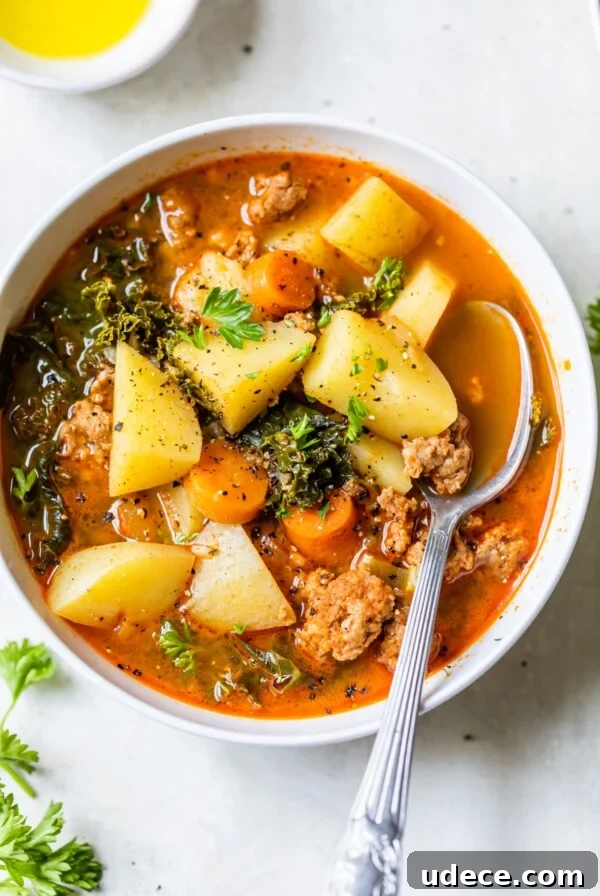 a bowl of soup with sausage and potatoes