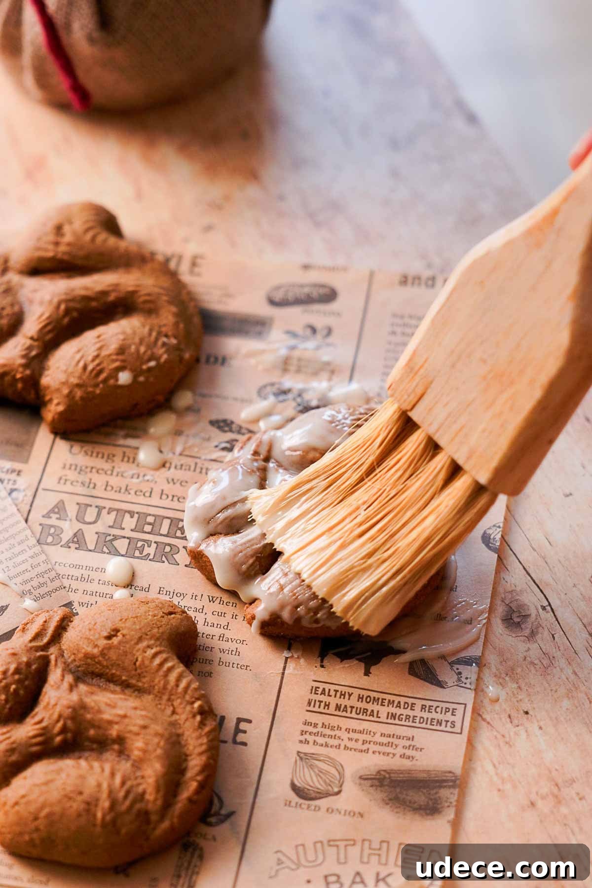 brushing orange glaze over squirrel shaped gingerbread cookie