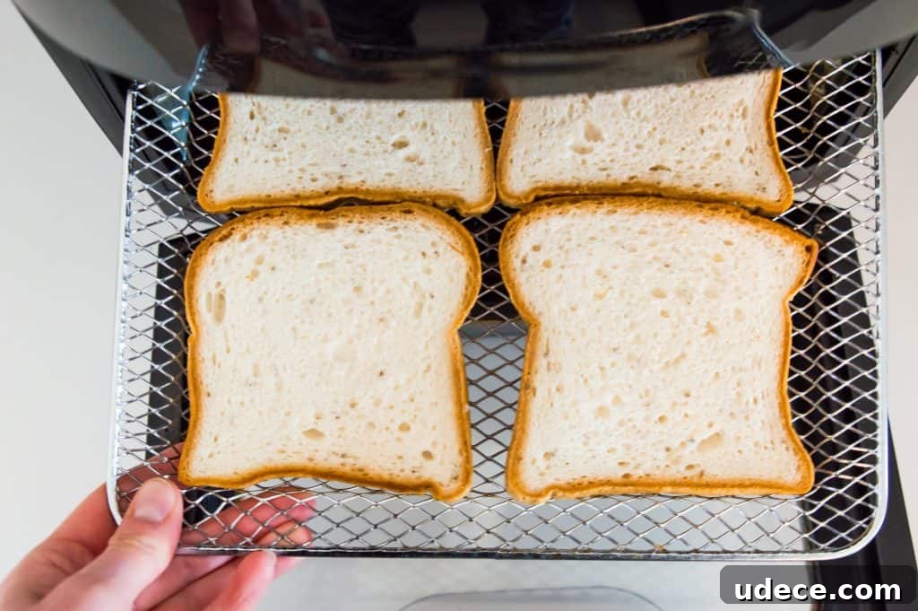 Four pieces of bread on the rack of an air fryer.