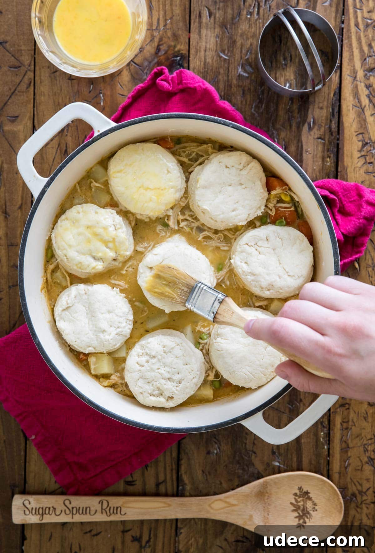 brushing egg over biscuits in pot