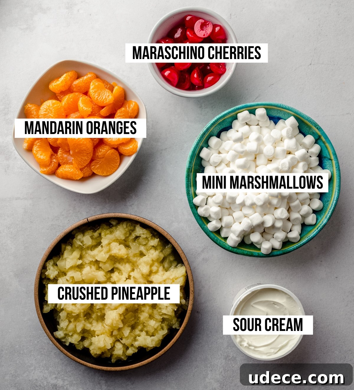 Aerial photo of ingredients for ambrosia salad labeled with text overlay to identify each ingredient.
