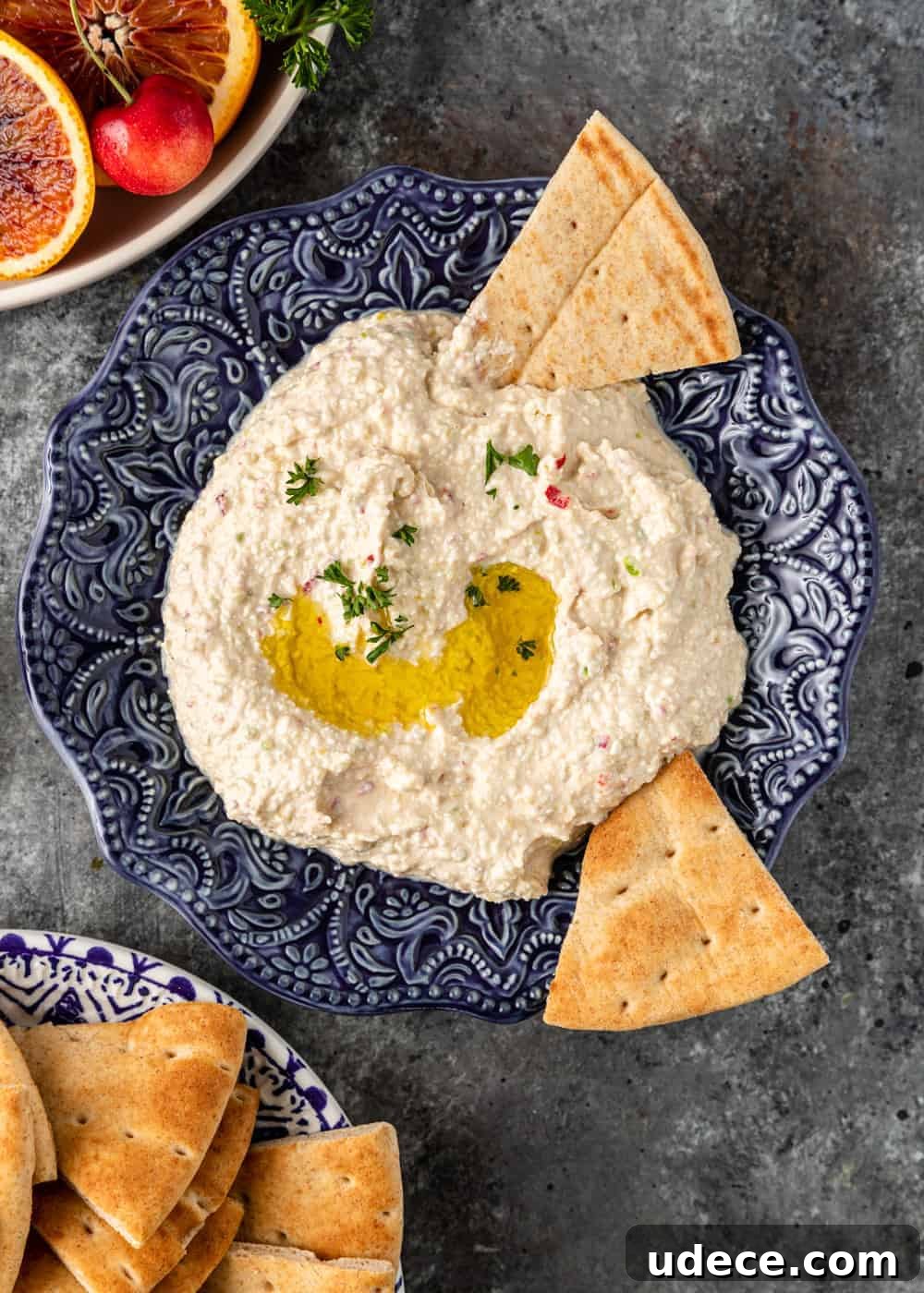 overhead: Greek spicy cheese dip in an ornate blue bowl with flatbread triangles