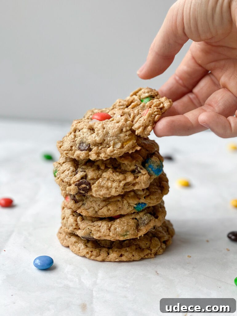 hand breaking the top cookie on a stack
